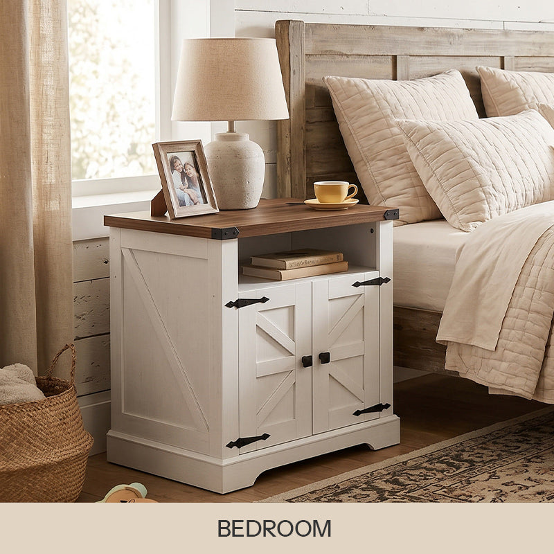 White farmhouse nightstand with dark wood top and barn doors styled next to a bed with a lamp.