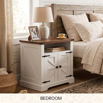 White farmhouse nightstand with dark wood top and barn doors styled next to a bed with a lamp.