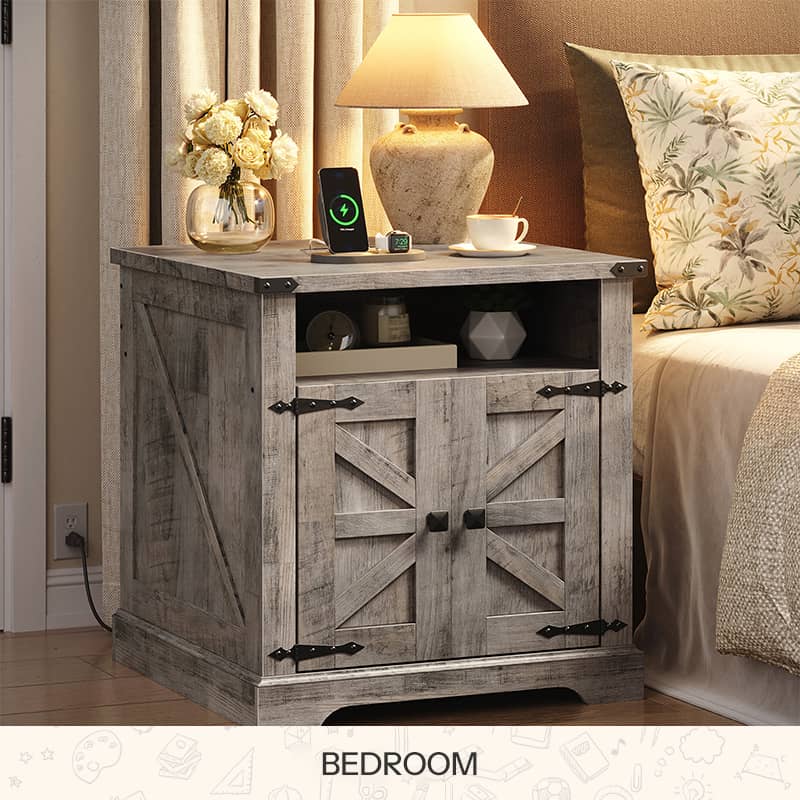 White farmhouse nightstand with dark wood top and barn doors styled next to a bed with a lamp.