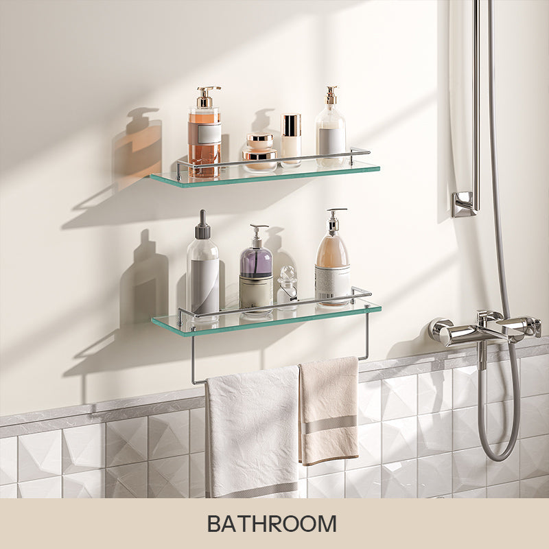 Set of 2 wall-mounted tempered glass bathroom shelves with chrome railings and a towel bar holding toiletries.