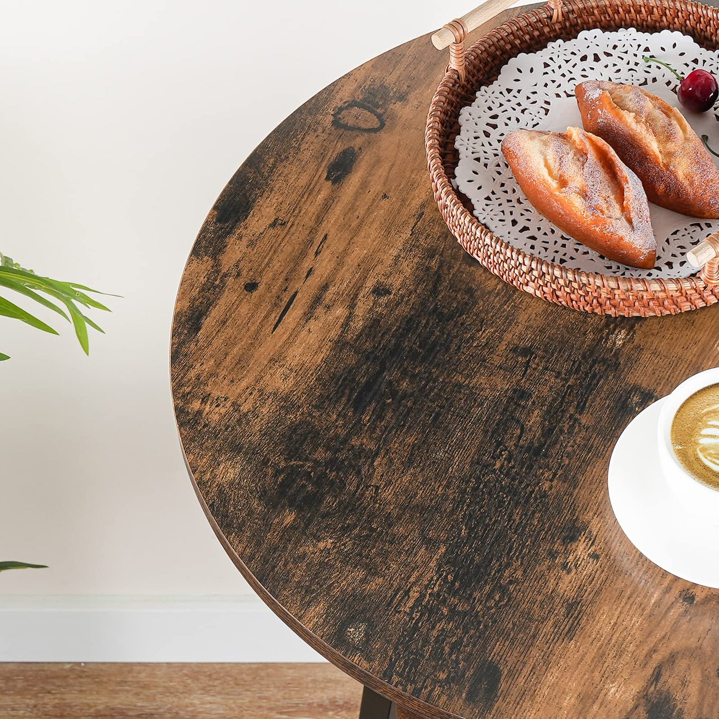 Wooden table with a basket of pastries and a cup of coffee on a white background