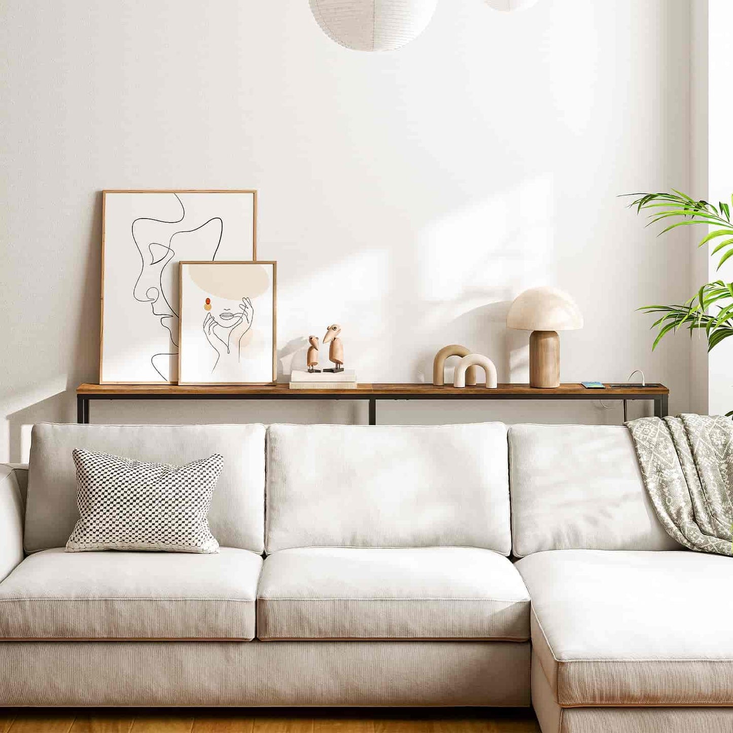 Modern living room with a white sofa, decorative pillows, and wall art.
