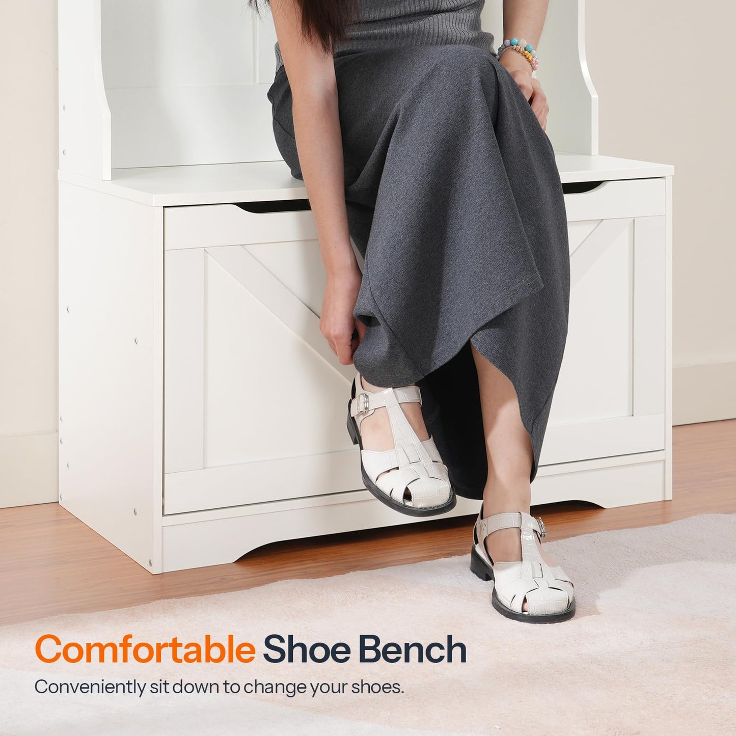 Close up of a woman sitting comfortably on the white entryway shoe bench changing her footwear in a mudroom.