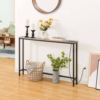 Console table in a living room with decor items including candles, flowers, and a plant.