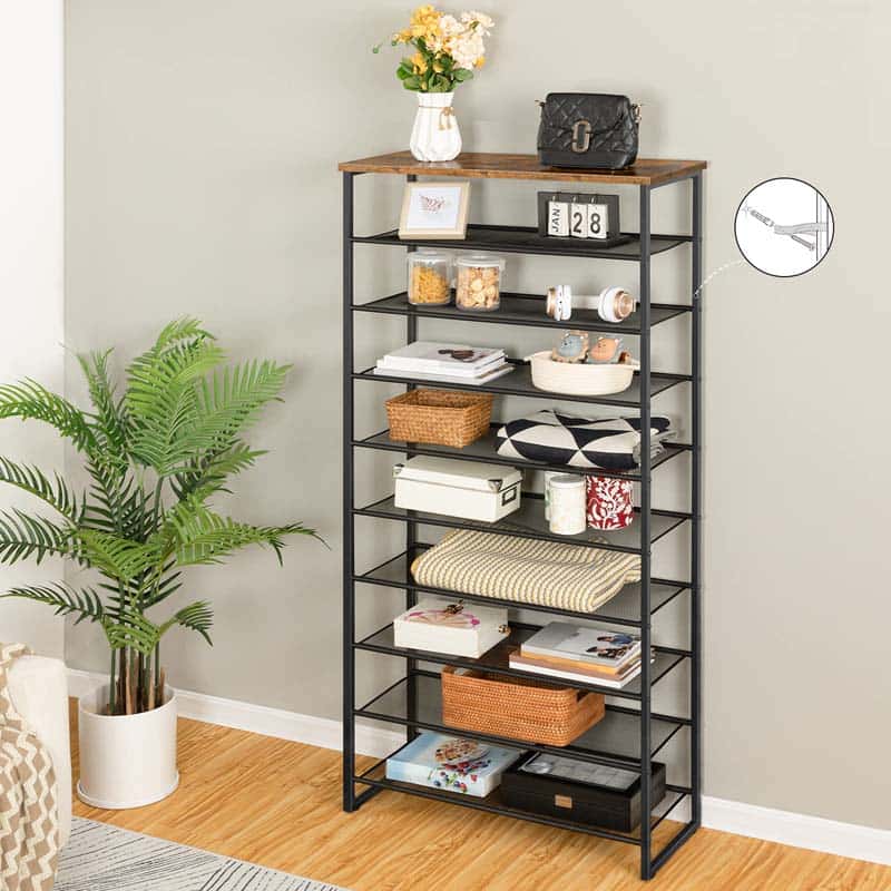 A tall black metal shelving unit with a rustic brown wood top, styled with home decor items in a room corner with a potted plant and wood floor.
