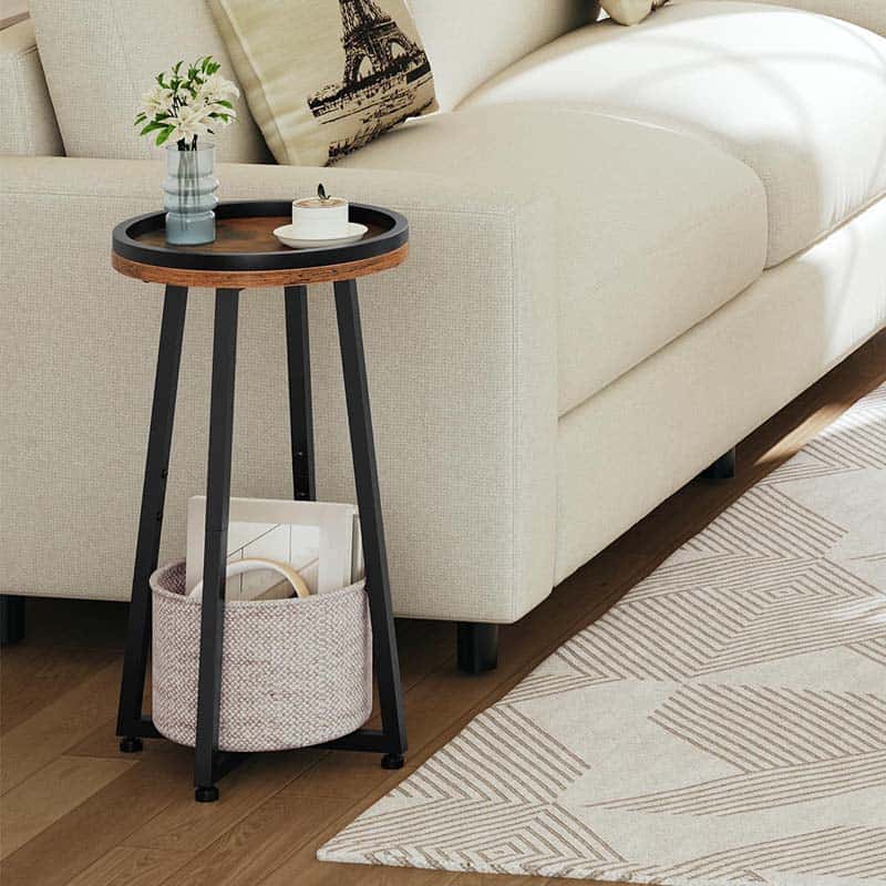 Skinny round sofa side table holding a ceramic tea mug placed next to a modern cream white fabric couch.