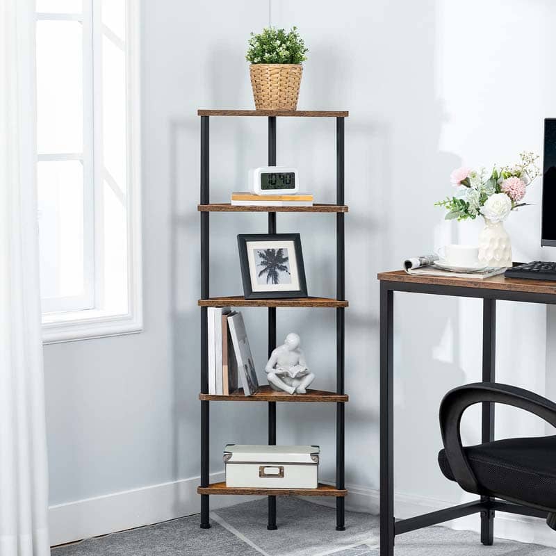 A 4-tier wooden and metal ladder shelf styled in a home office setting next to a desk, holding books, a framed picture, a small statue, a storage box, a digital clock, and a potted plant.