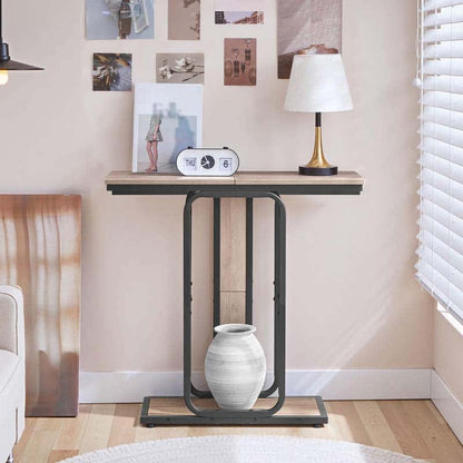 Compact hallway foyer table placed against a bedroom wall under picture frames holding a white clock.