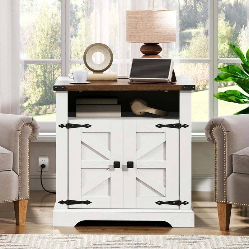 A white sideboard cabinet with a dark wood top, black metal hardware, and two barn-style doors, styled in a bright living room setting.