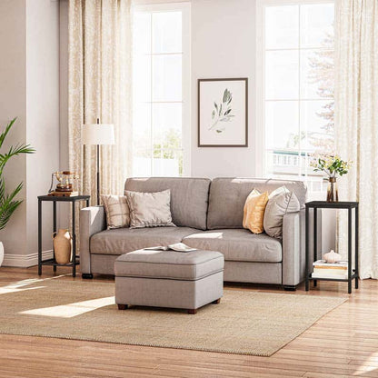 Gray sectional sofa with cushions in a living room setting with large windows and decorative elements.