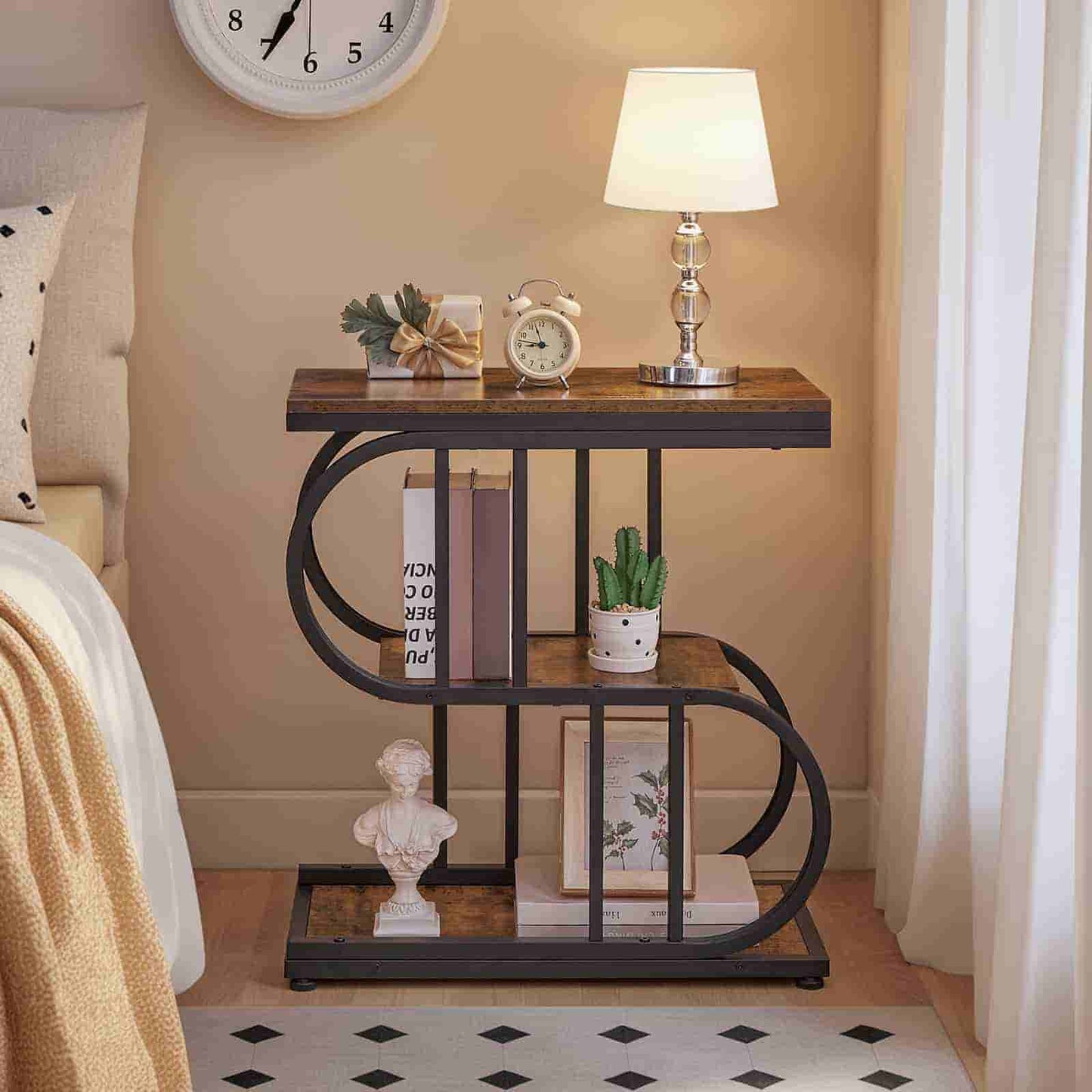 Decorative side table with books, clock, and lamp in a bedroom setting