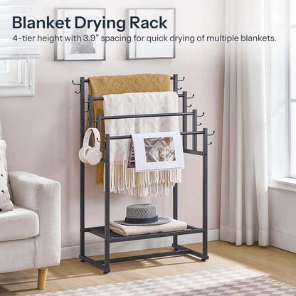 Blanket drying rack with blankets, a hat, and headphones on a stand in a room.