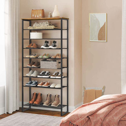 Shoe rack with various shoes on shelves in a room with a bed and wall art.