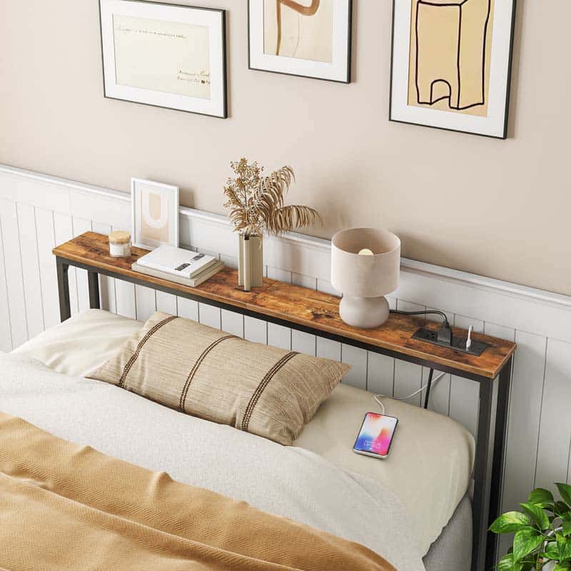 Bedroom with a wooden headboard shelf, books, a lamp, and a smartphone.