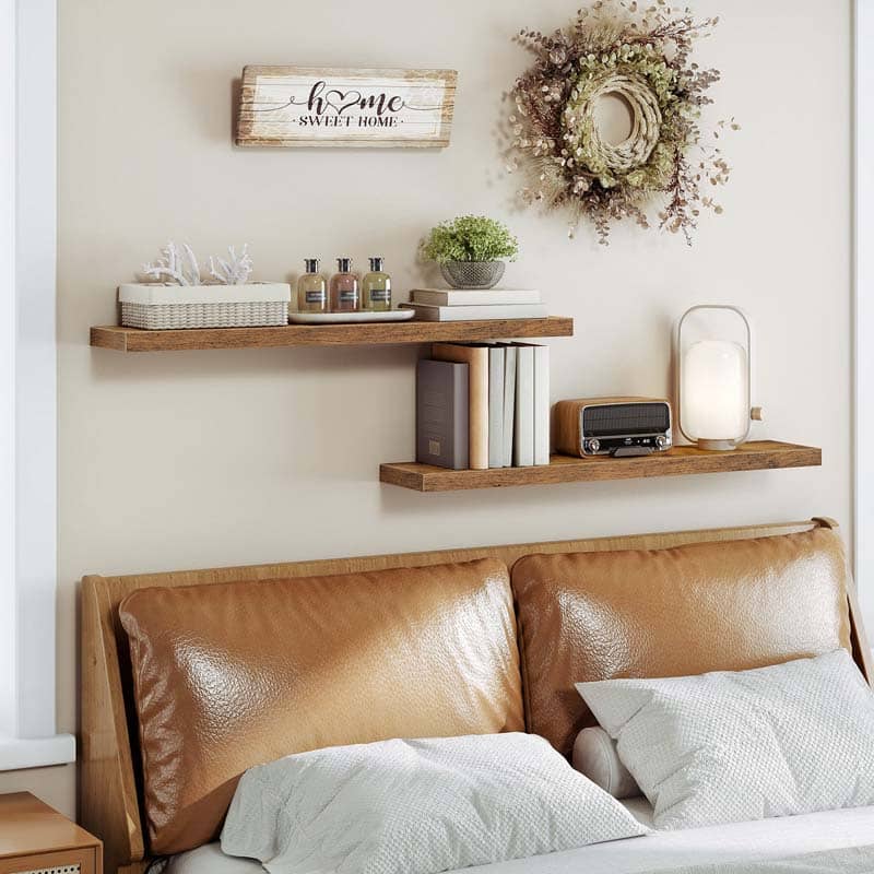Staggered bedroom floating shelves mounted above a leather headboard for warm decor.