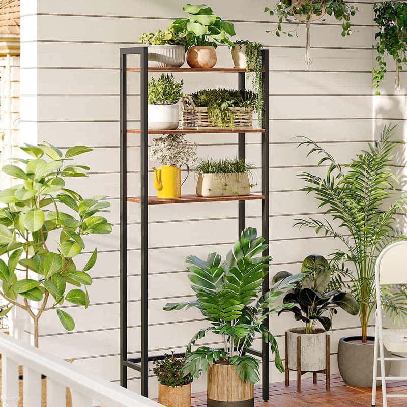 Tall metal shelving unit with plants on a wooden deck