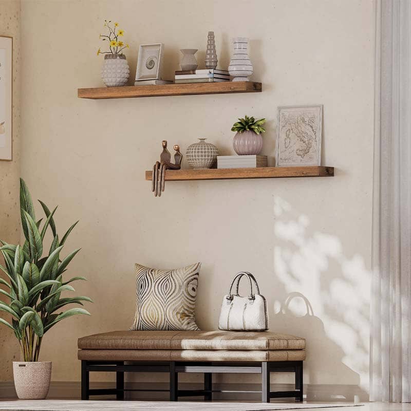 Rustic wall hanging shelves arranged in a staggered layout over an entryway storage bench for home decorations.
