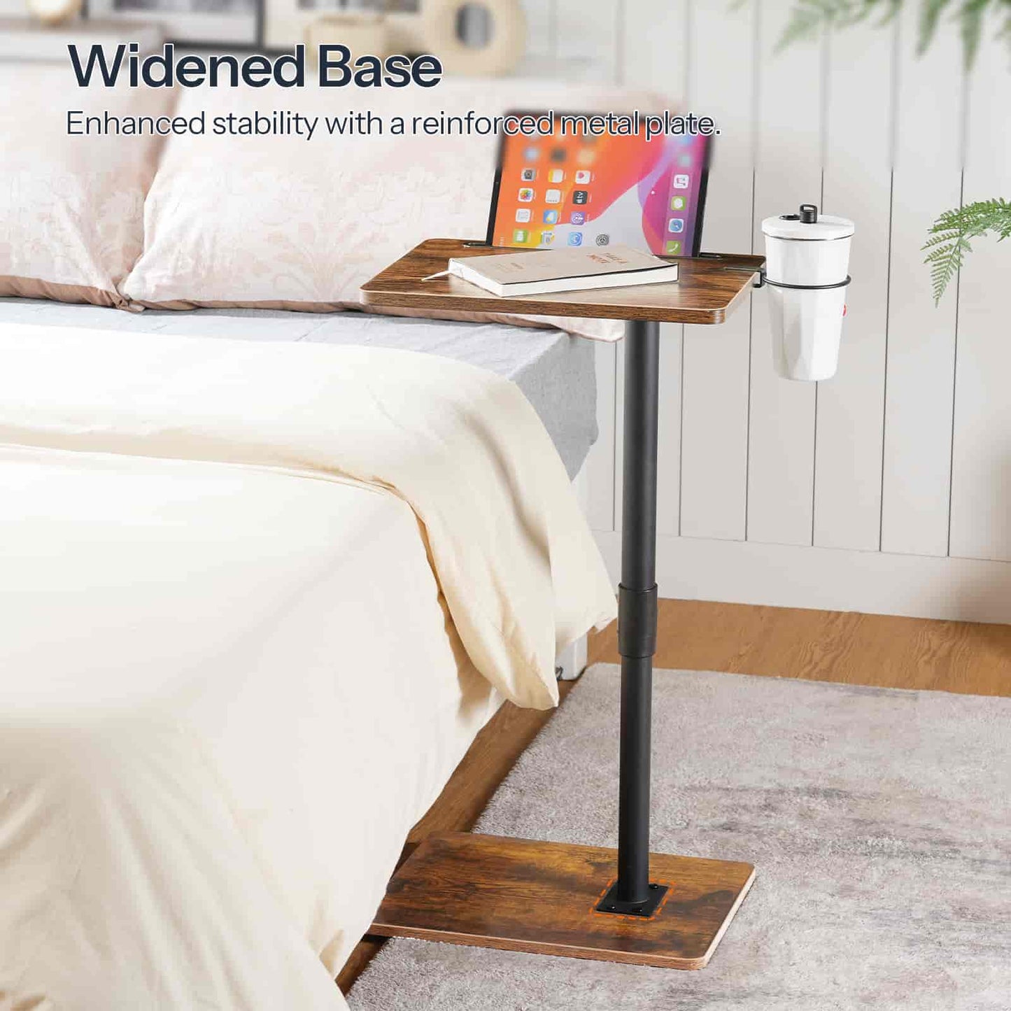 Bedside table with widened base and reinforced metal plate, placed on a bed.