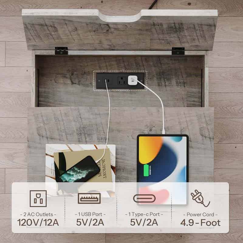 An open storage compartment with a wood-look interior reveals a built-in power outlet and charging setup, with a phone and tablet plugged in. A text overlay at the bottom lists features: 2 AC outlets 120V/12A, 1 USB port 5V/2A, 1 Type-c port 5V/2A, and a power cord 4.