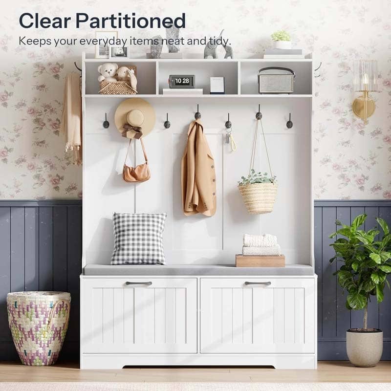 White storage bench with hooks and shelves in a room with floral wallpaper.