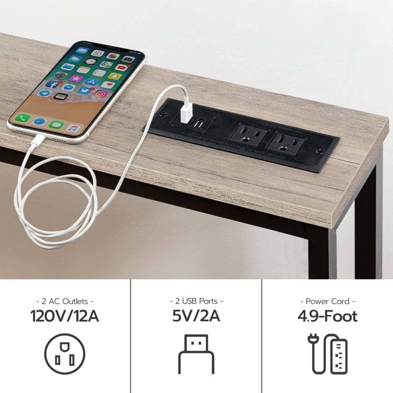 Black 5-in-1 power strip panel with 2 AC outlets and 2 USB ports mounted on a light wood table, shown with a smartphone charging via a white cable. Infographic text at the bottom lists specifications: 2 AC Outlets 120V/12A, 2 USB Ports 5V/2A, and Power Cord 4.