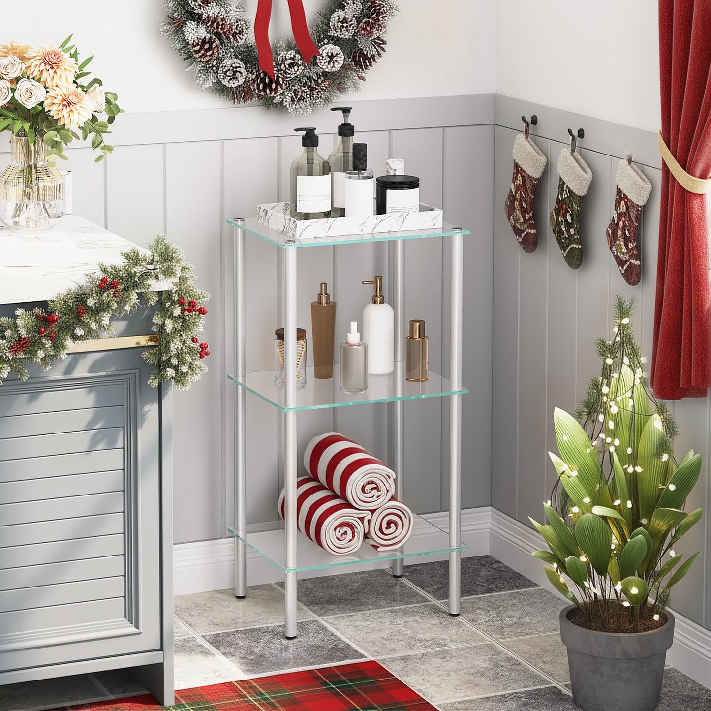Bathroom corner with glass shelving unit, Christmas decorations, and plants.