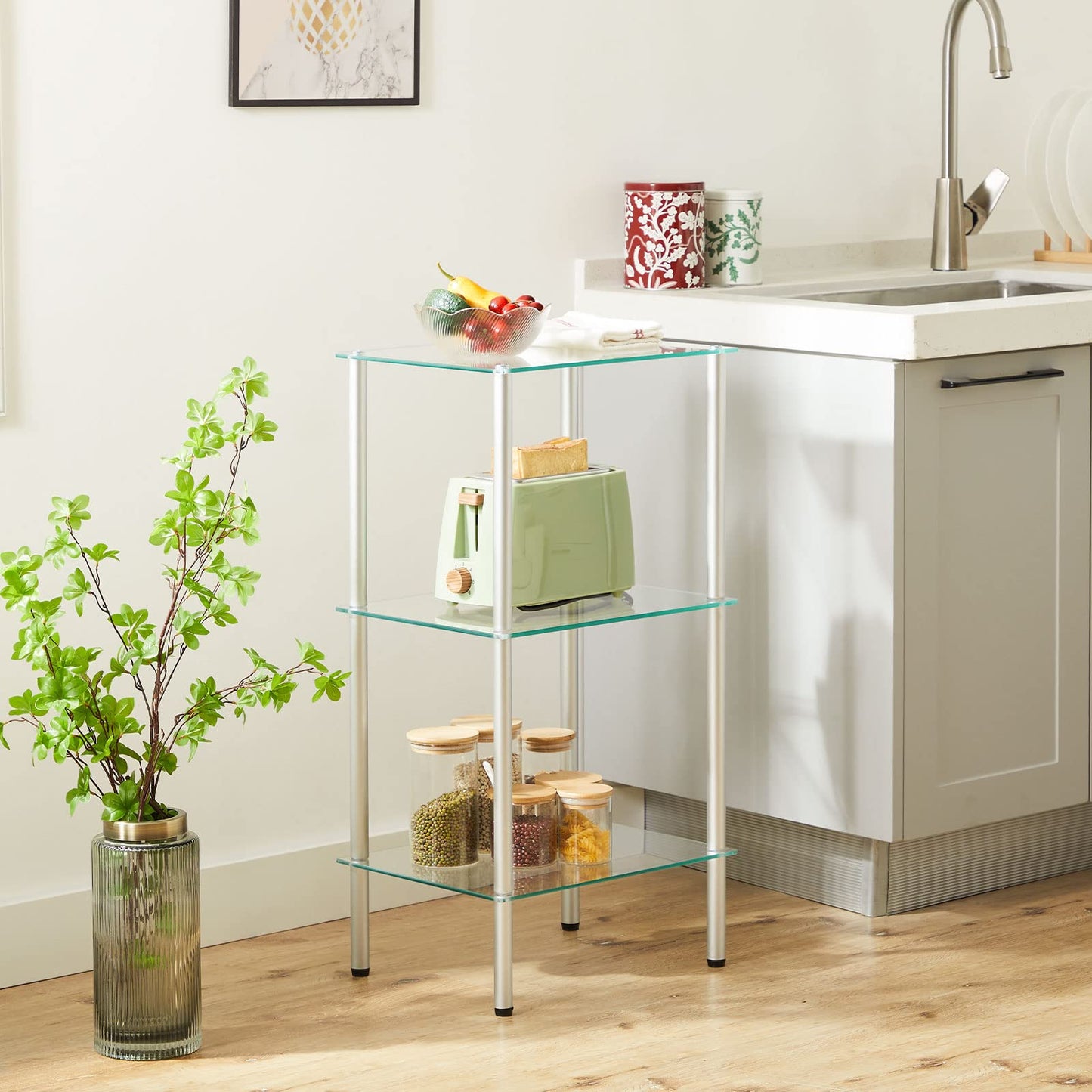 Glass kitchen cart with shelves next to a sink in a kitchen setting.