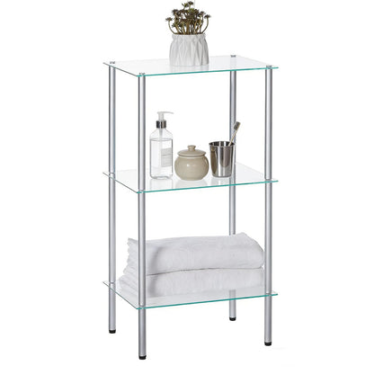 Glass shelf unit with towels, bottles, and a plant on a white background