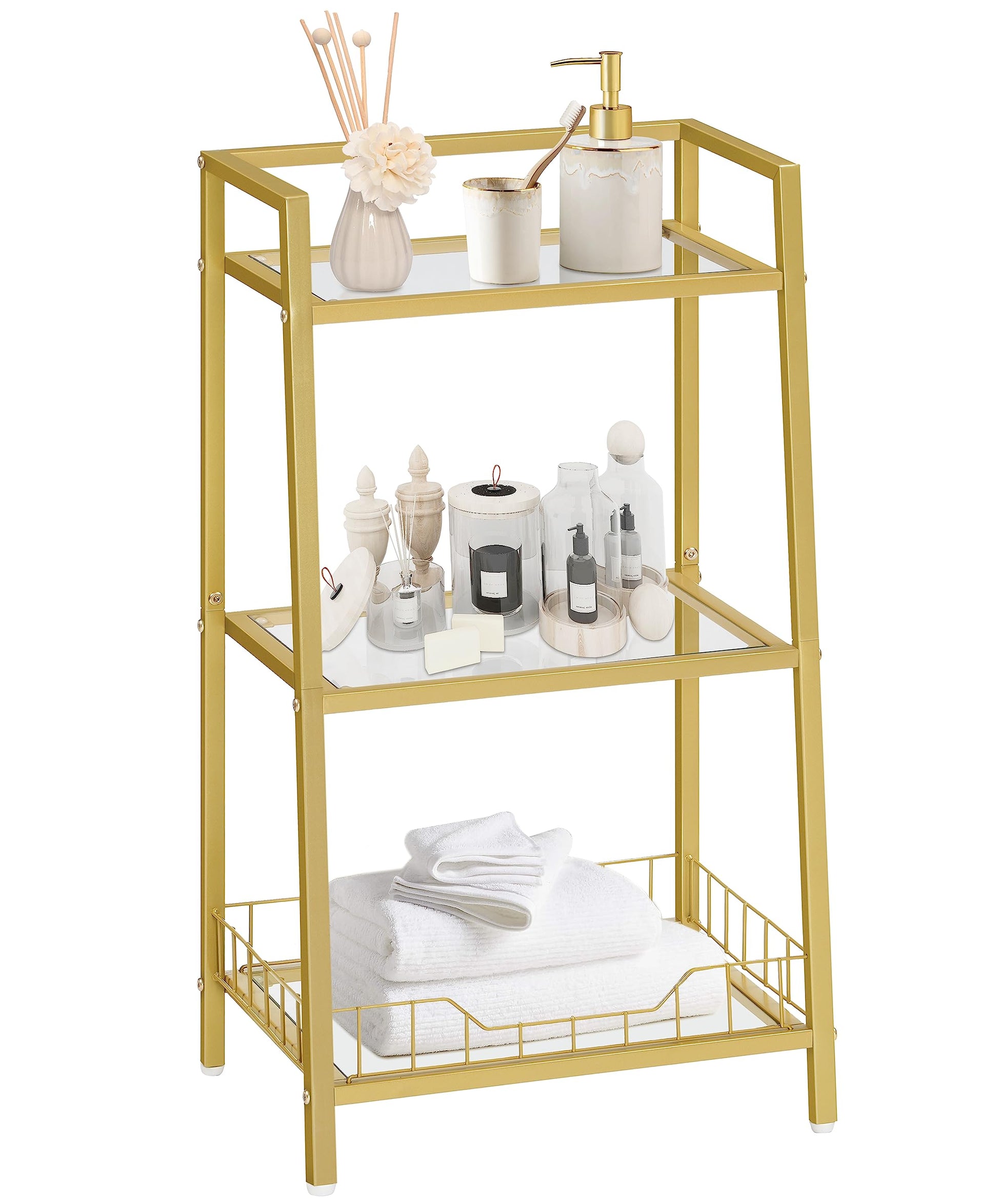 Gold metal shelf with glass shelves holding various items on a white background