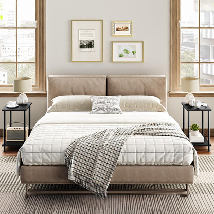 Neatly made bed in a bedroom with side tables and framed pictures on the wall.