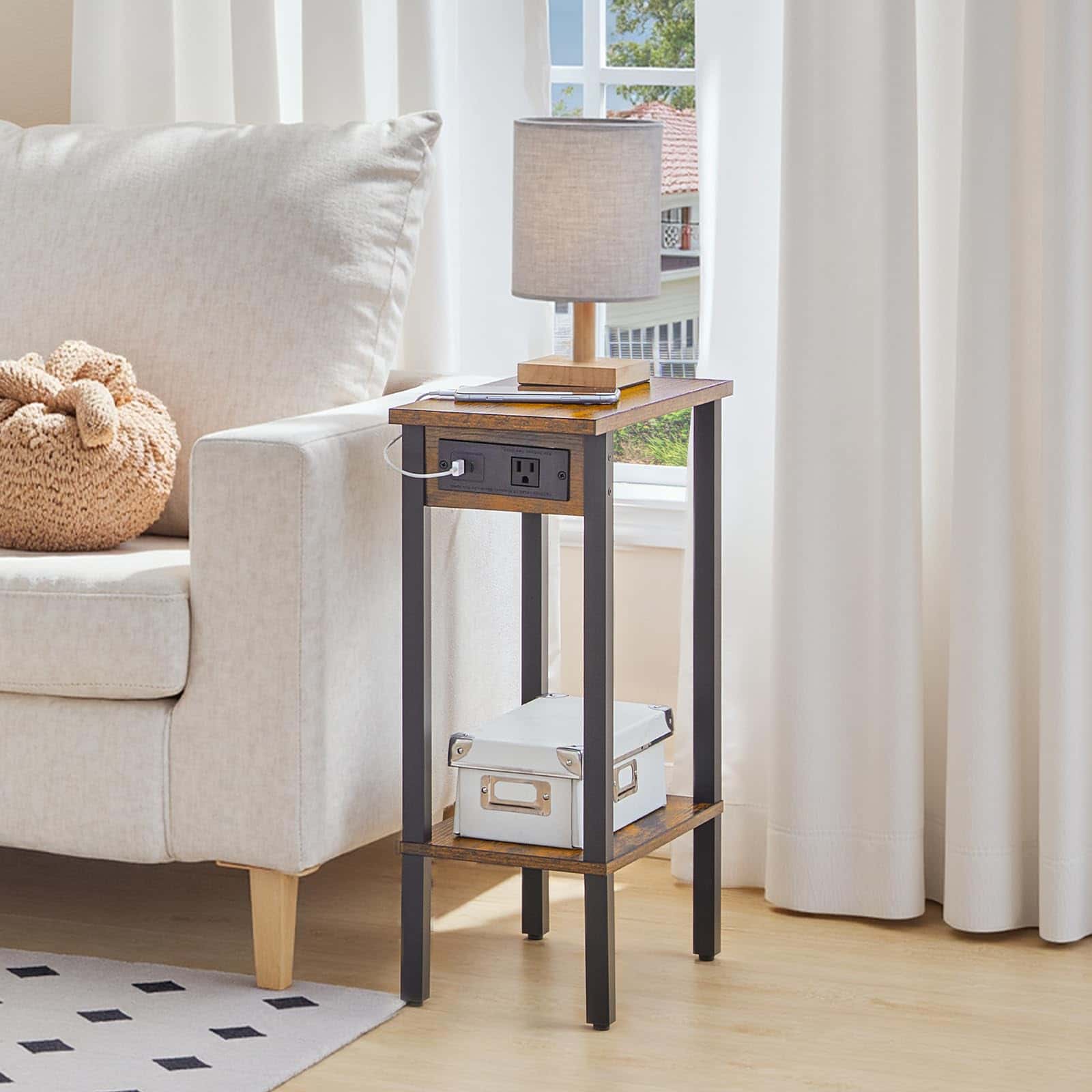 Side table with lamp and power outlet next to a beige sofa in a living room.