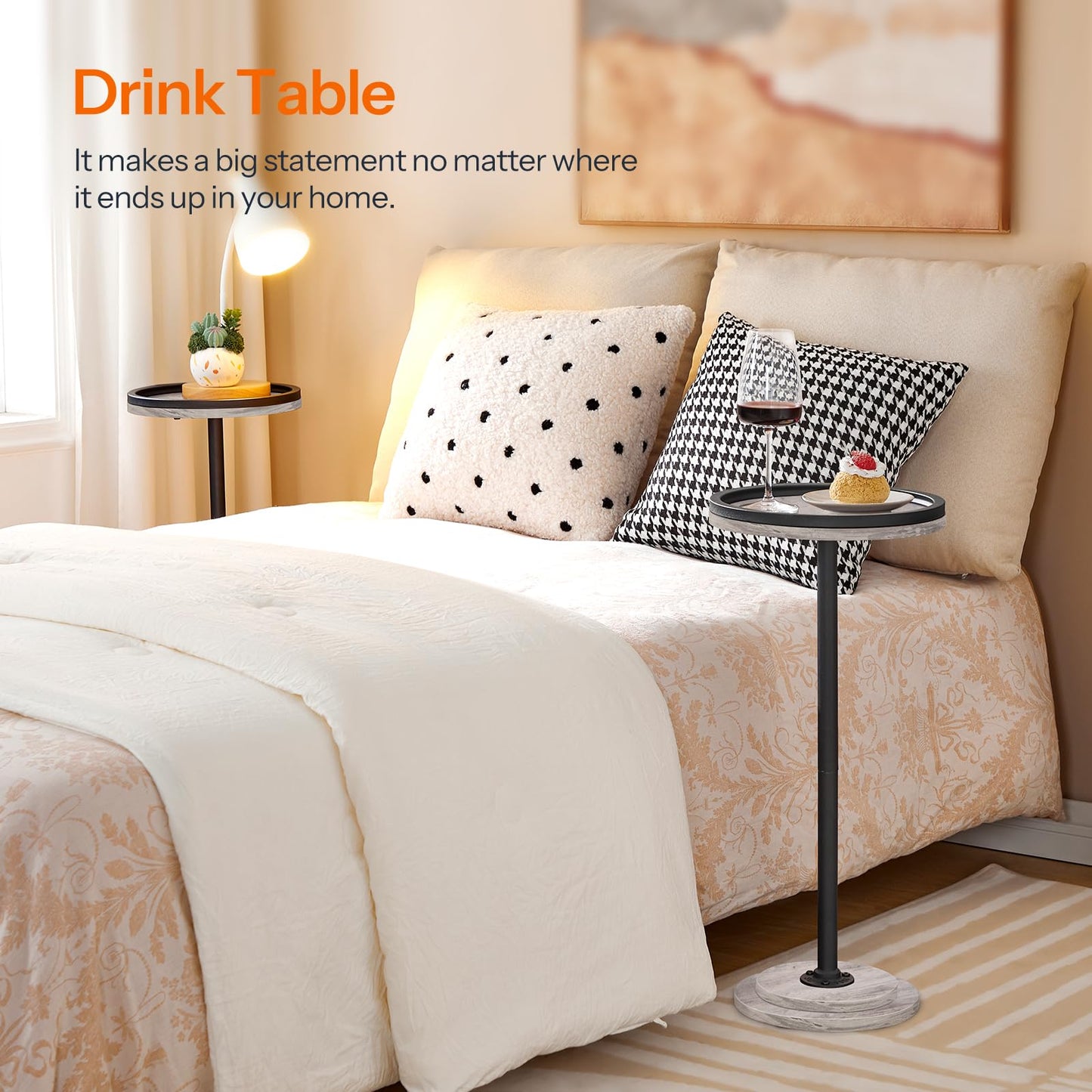 Small black drink table next to a bed with pillows and a lamp.