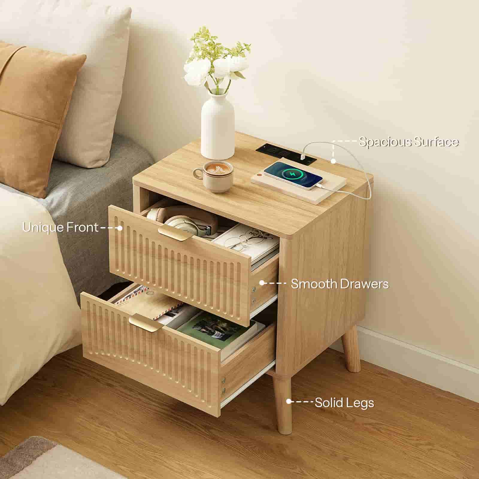 Angled top view of the nightstand with both drawers open, displaying large interior storage capacity next to a bed.