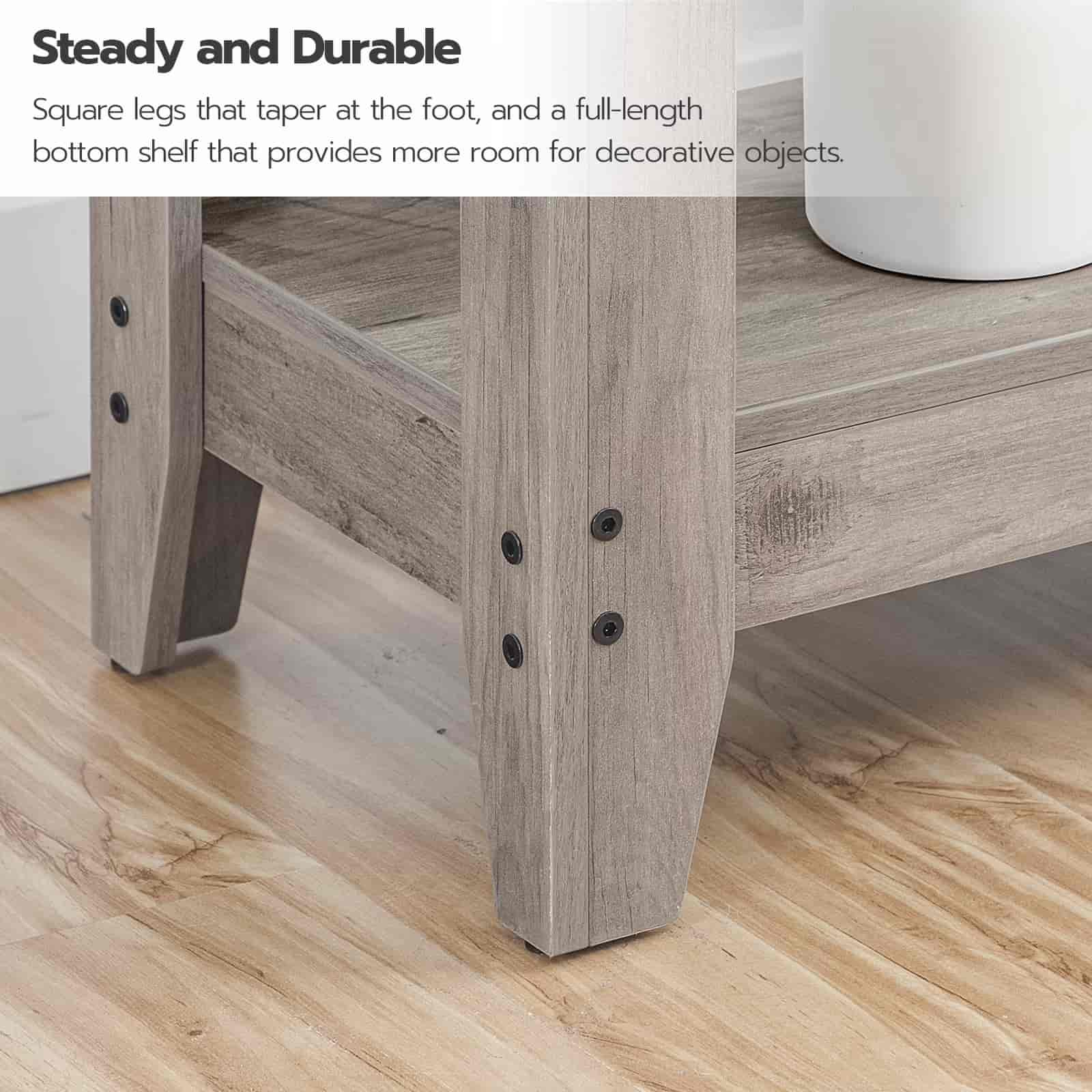 Wooden table with square legs and a full-length bottom shelf on a wooden floor.
