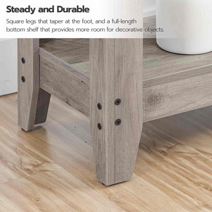 Wooden table with square legs and a full-length bottom shelf on a wooden floor.