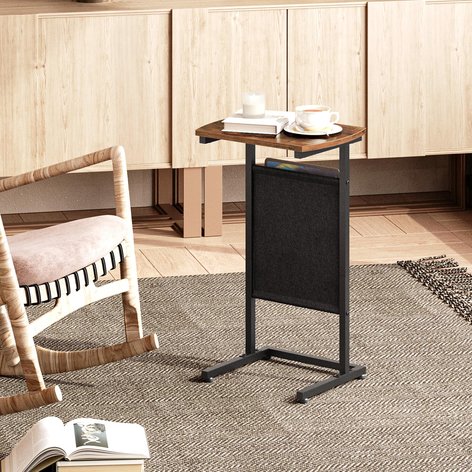 Small wooden table with a black stand in a room with wooden cabinets and a chair.