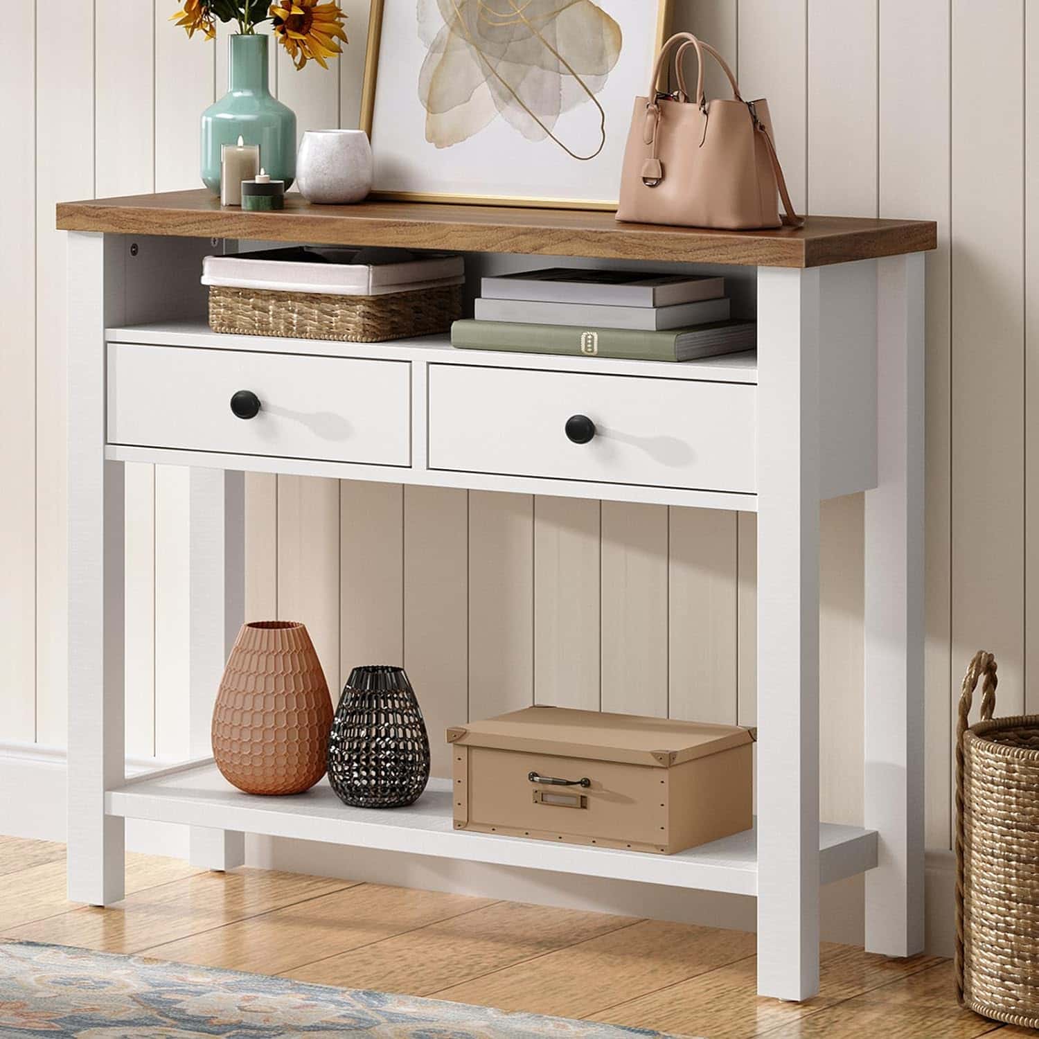 White console table with wooden top, drawers, and shelves against a light-colored wall.