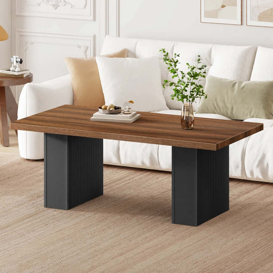 Wooden coffee table with black legs in a living room setting.