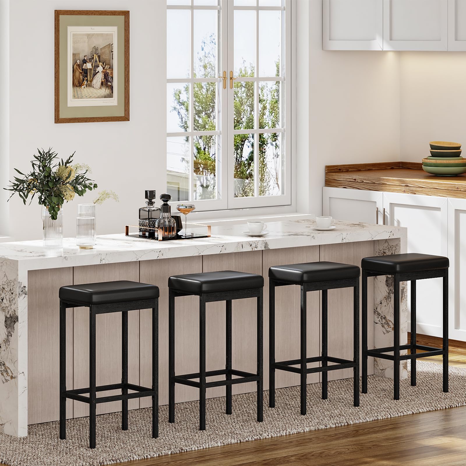 Four breakfast bar stools lined up neatly under a long kitchen island countertop.