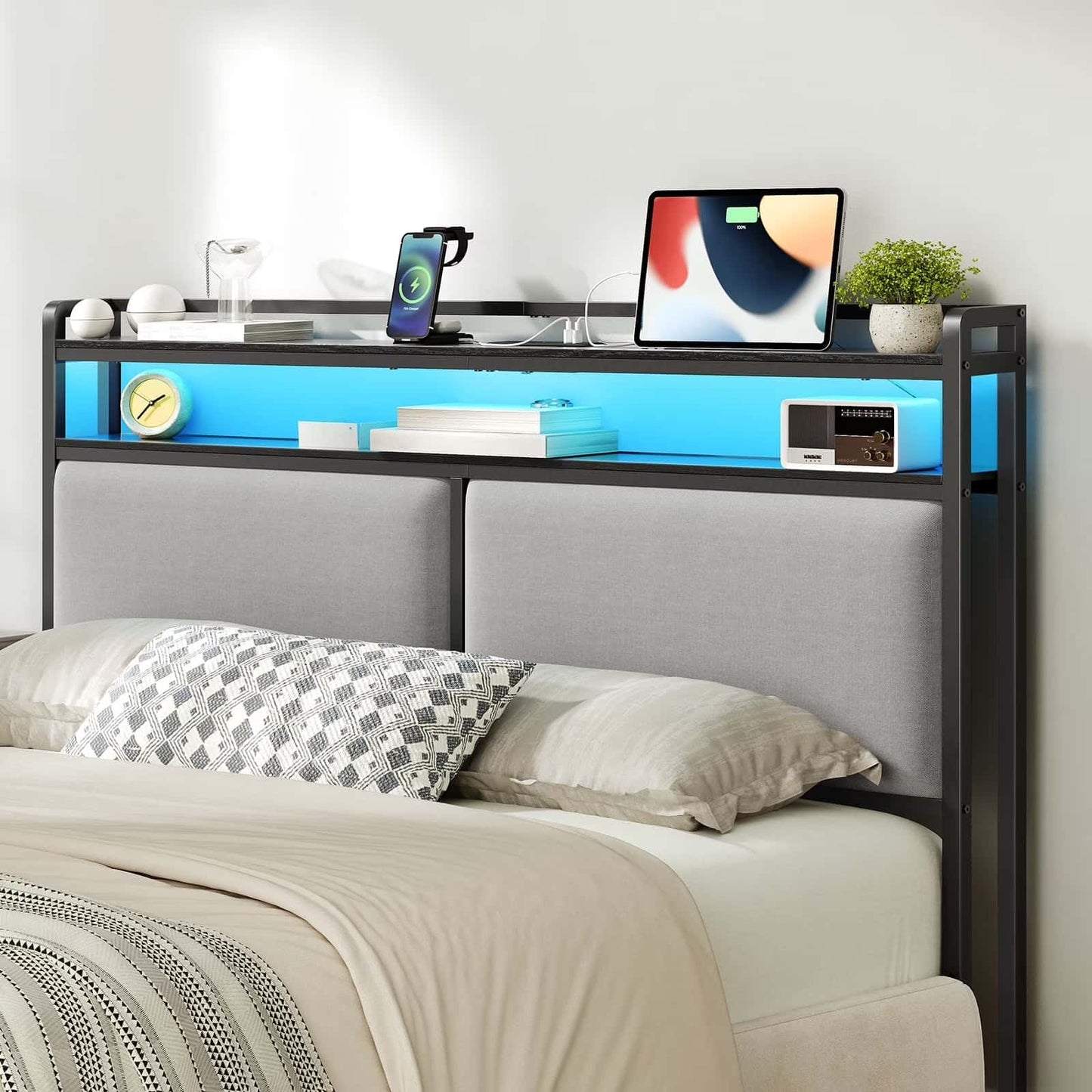 Bedroom setup with a bed, desk, and electronic devices on a white wall background