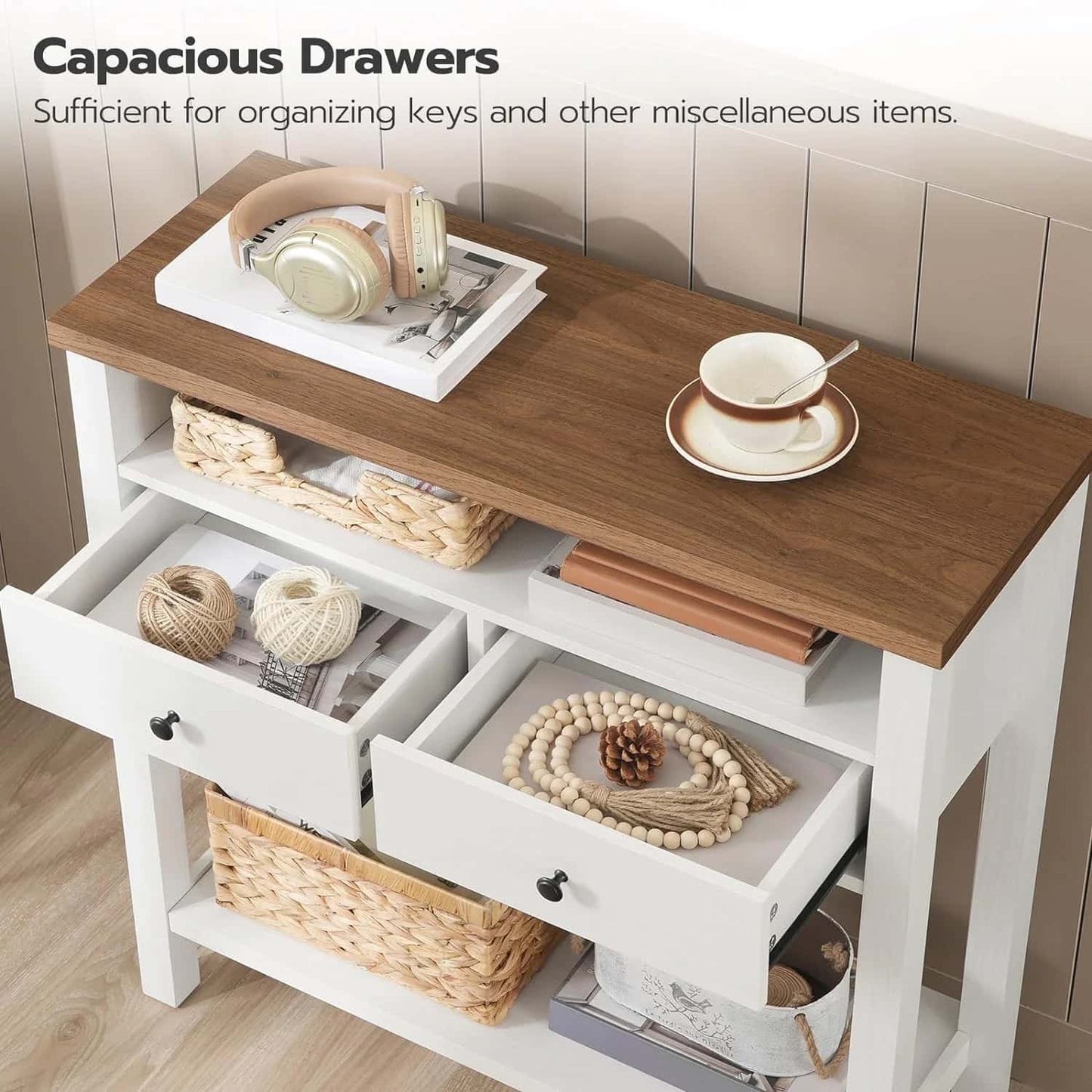 Wooden console table with open drawers containing decorative items on a wooden floor.