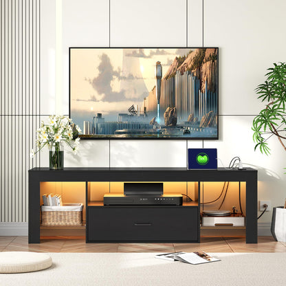 Modern black TV stand with a mounted television displaying a scenic image, in a room with decorative elements.