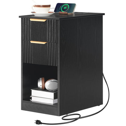 Black nightstand with two drawers and a small shelf, featuring a phone, cup, and books on top.