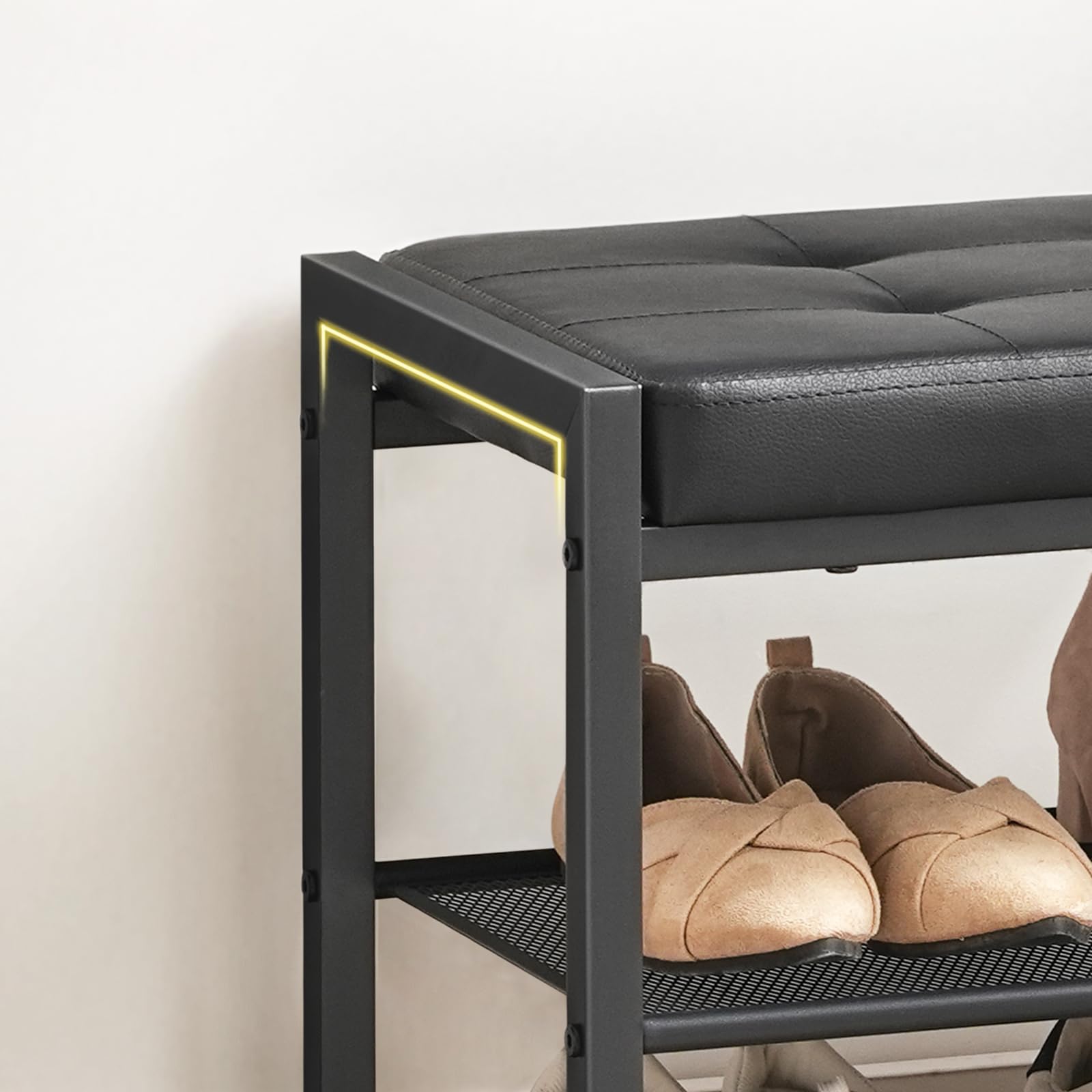 Black shoe rack with cushioned top holding a pair of brown shoes on a white background