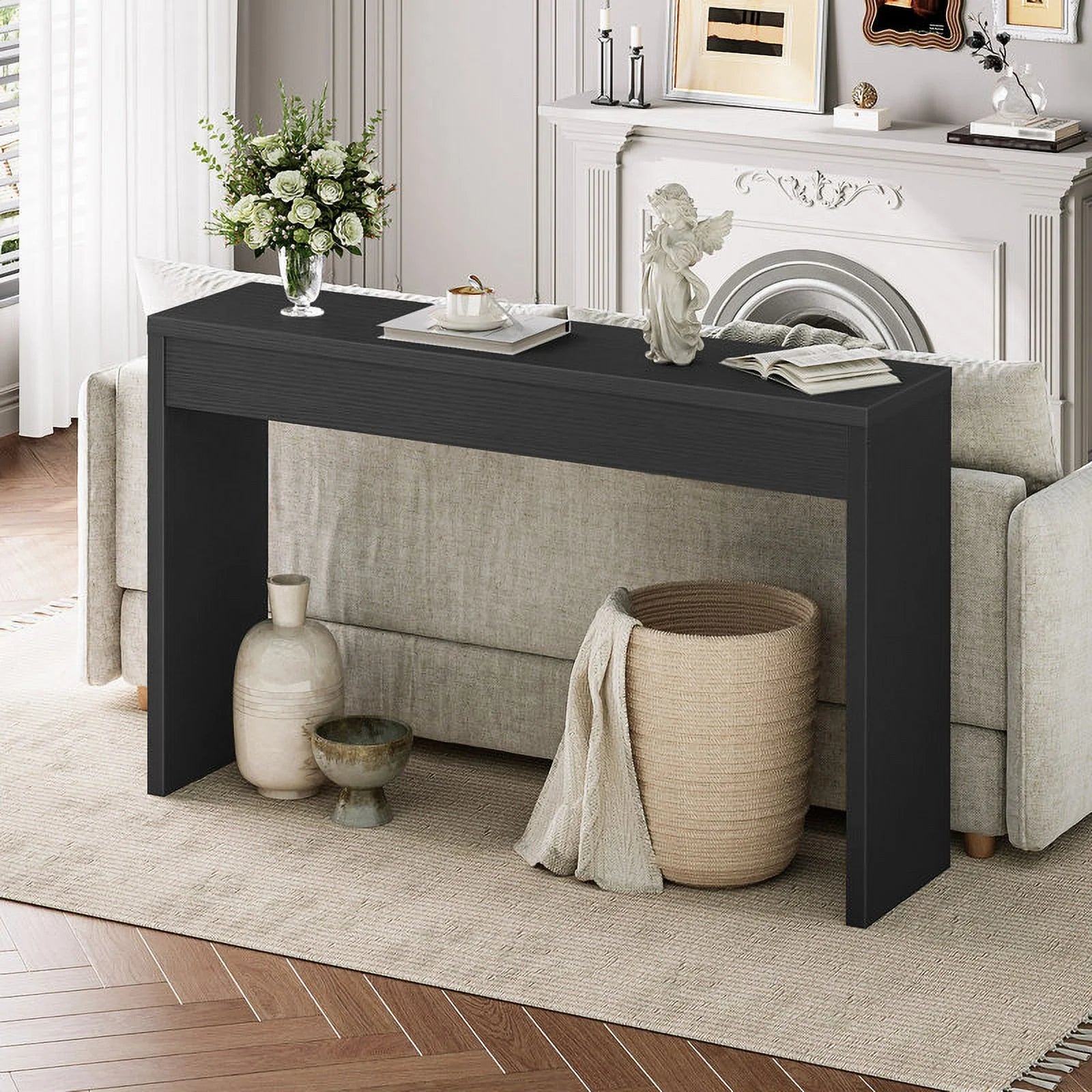 Black console table in a living room with decorative items and a fireplace.