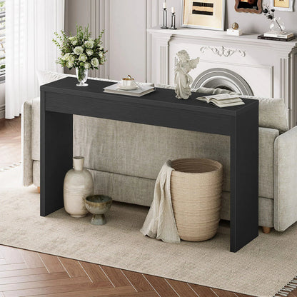 Black console table in a living room with decorative items and a fireplace.