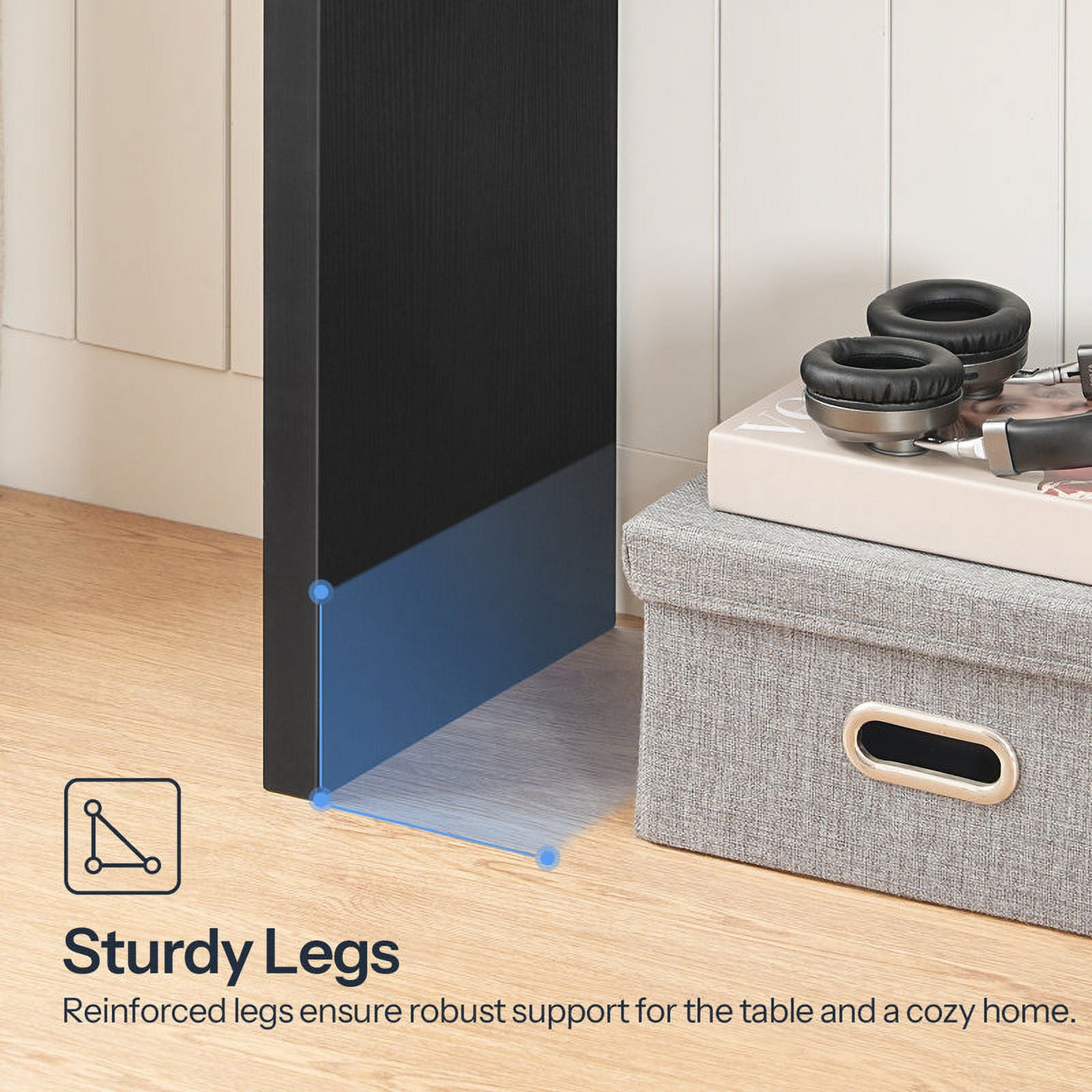 Gray storage box with a black TV stand and headphones on a wooden floor.