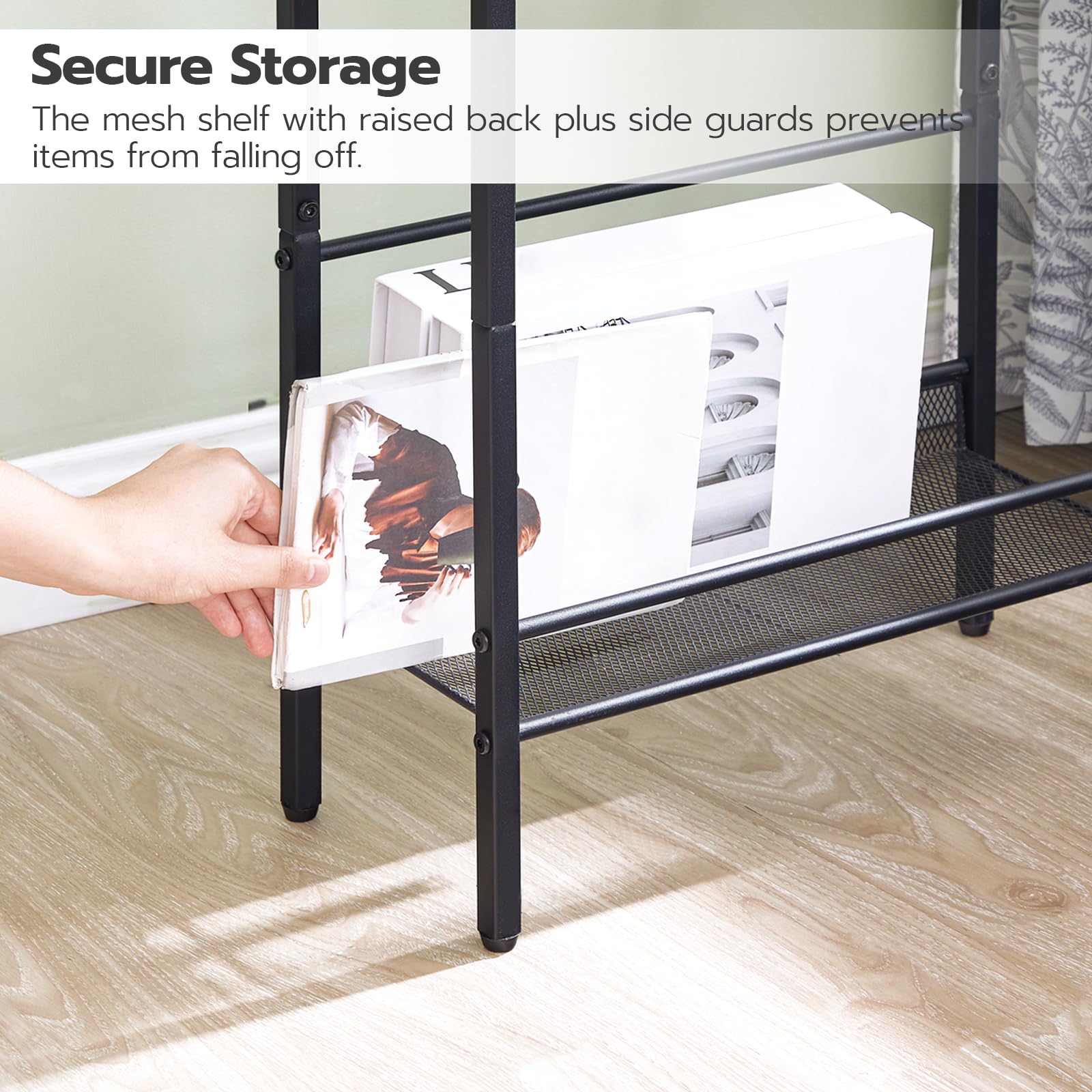 Black mesh shelf with raised back and side guards holding a photo frame, on a light wood floor.