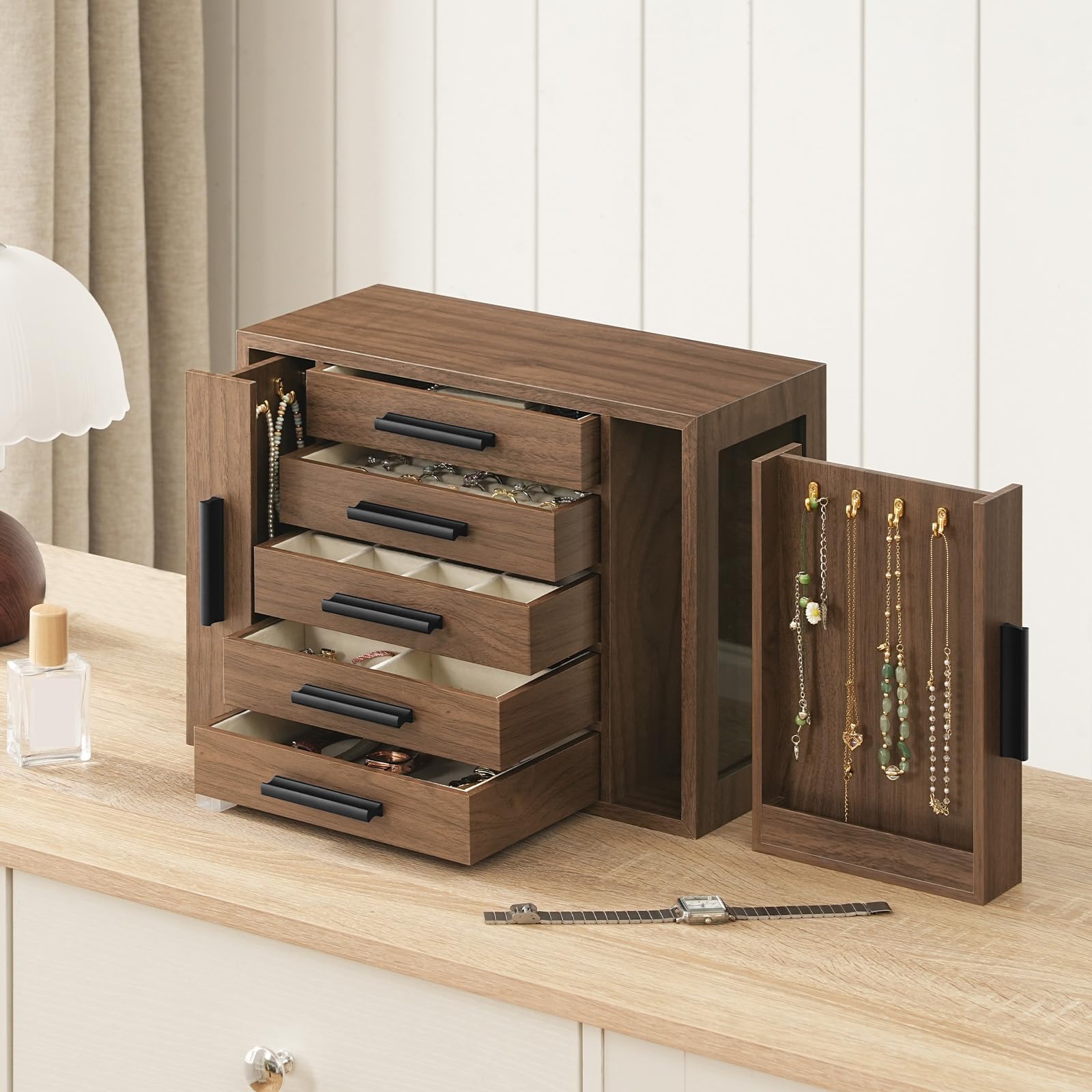 Wooden jewelry cabinet with open drawers and display area on a wooden surface.