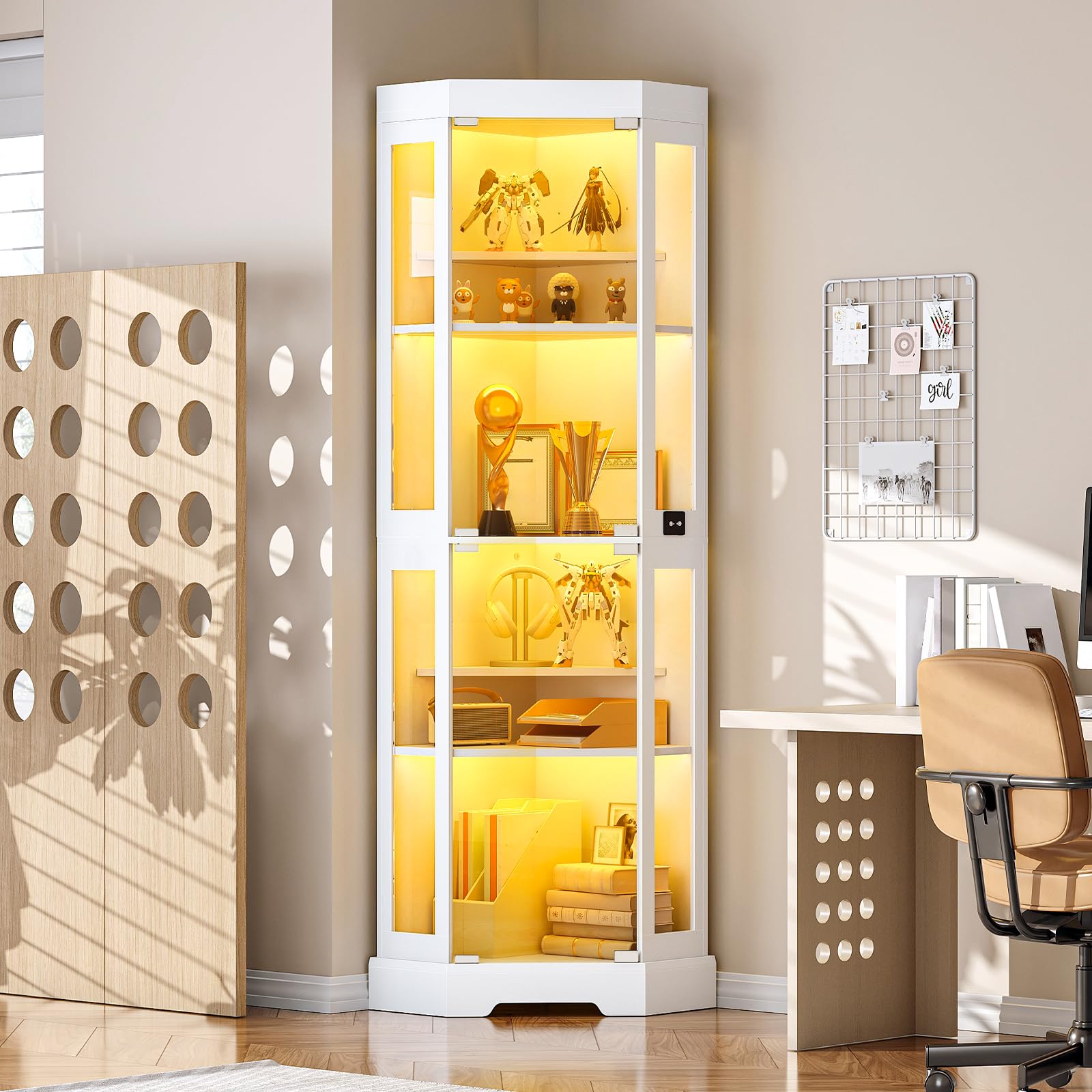 Tall white display cabinet with illuminated interior in a room with a chair and wall decor.